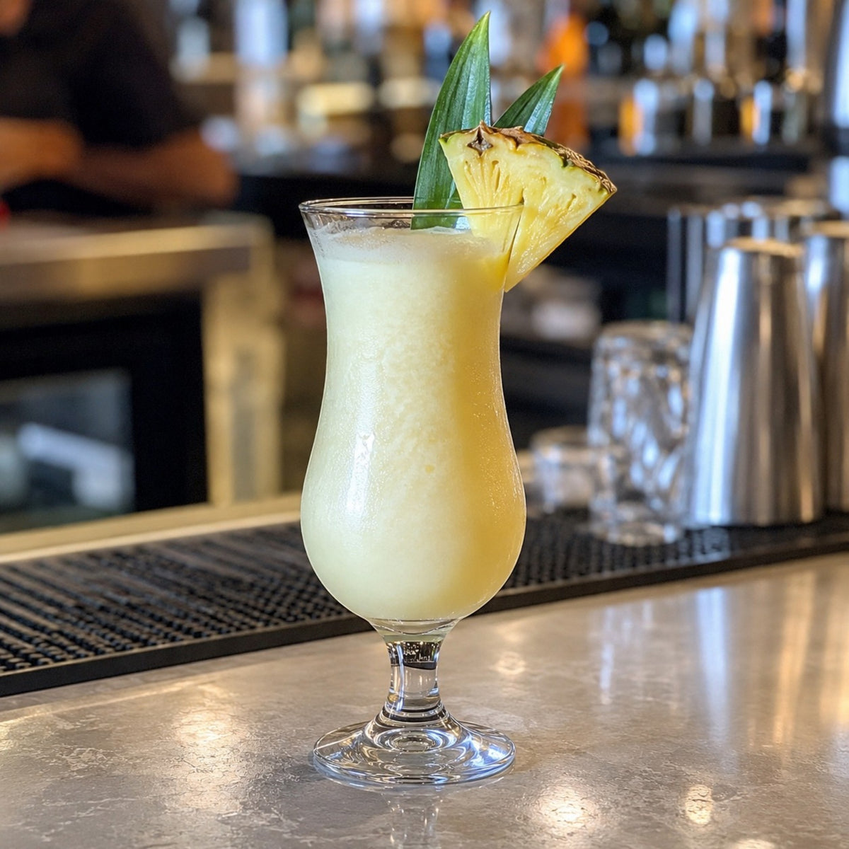 Copa huracán 15 1/2 oz con piña colada sobre barra de bar